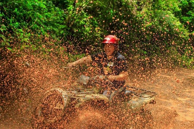 ATV Tour with Cenote swim, Ziplines, Transportation and Lunch Included - Riding the ATVs on a muddy jungle course